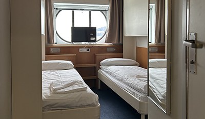 Twin-bed ensuite cabin with a porthole on an Irish Ferries ship