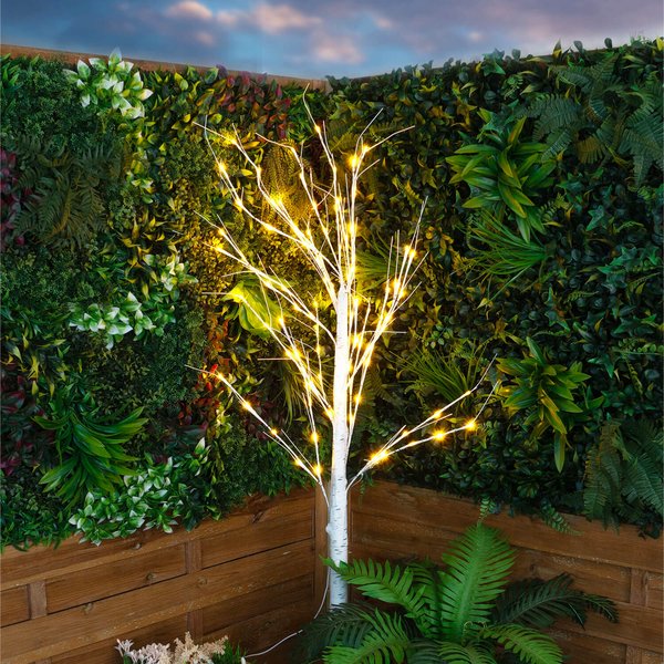 Light-up LED birch tree with warm white lights in a garden