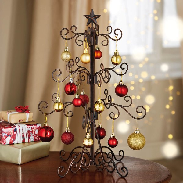 Table-top metal Christmas tree with scrolled feet and red and gold baubles