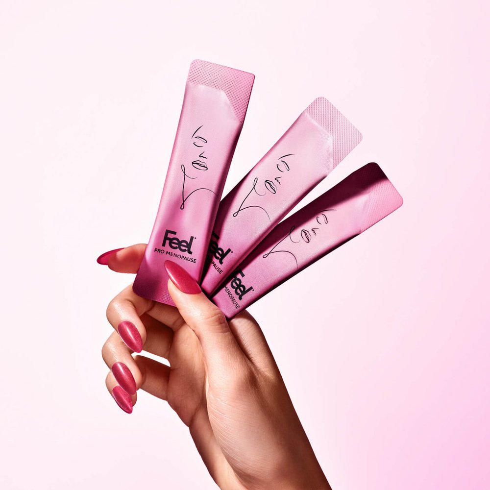 Three Feel Pro Menopause sachets held in a hand