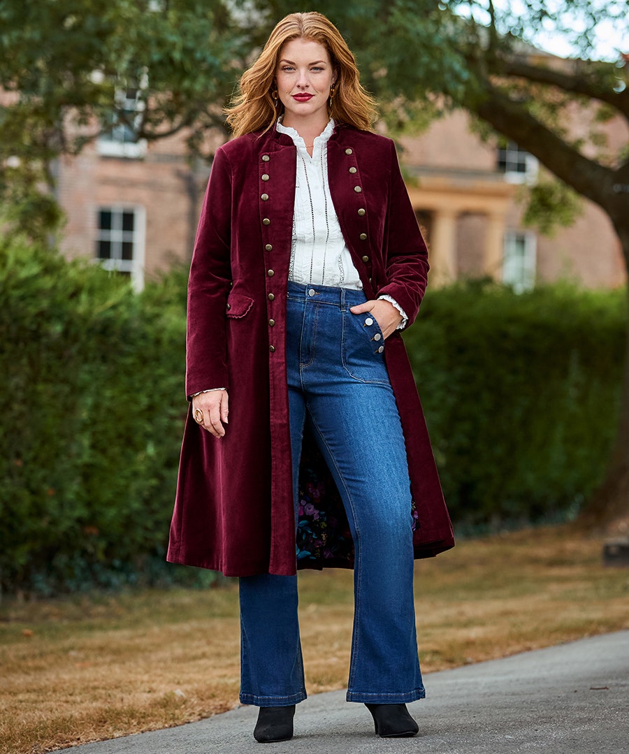 Woman in the Joe Browns Helena Military Long Moleskin Coat in burgundy with jeans