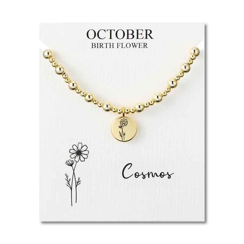 Philip Jones gold plated October cosmos beaded stretch bracelet on a gift card