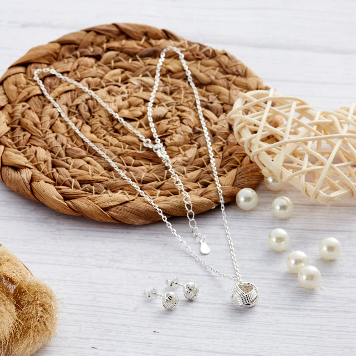 Philip Jones sterling silver friendship knot necklace and earrings on a wooden stand
