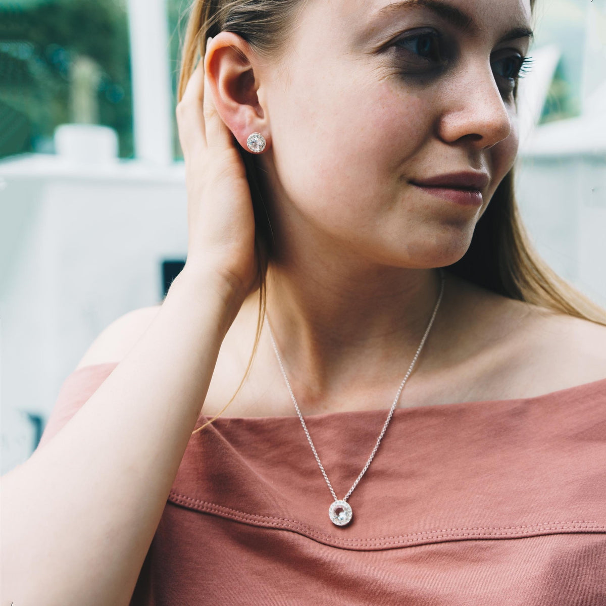 Woman wearing the Philip Jones halo necklace and stud earrings set