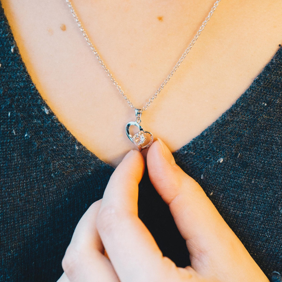 Philip Jones heart Mum necklace worn with a dark top