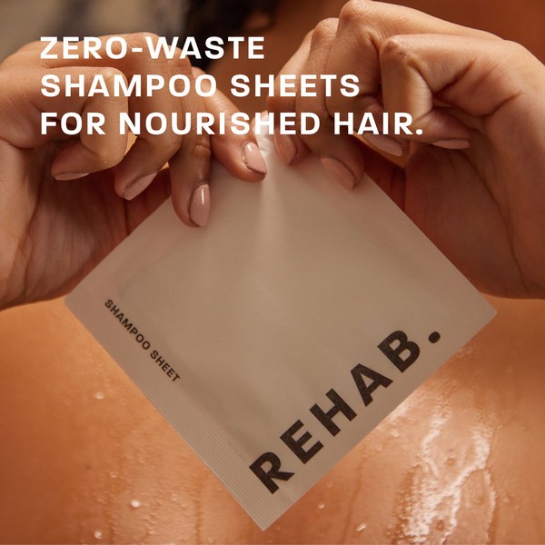 Hands holding a REHAB. Shampoo Sheet with the words zero-waste shampoo sheets