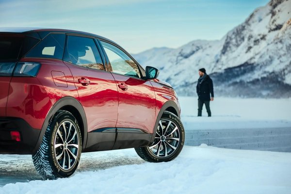 Red SUV fitted with Michelin Alpin 7 winter tyres parked in the snow