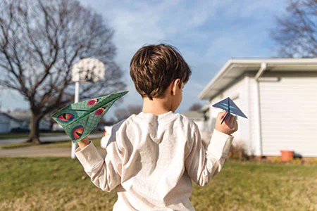 Boy playing with a toy aeroplane in a garden